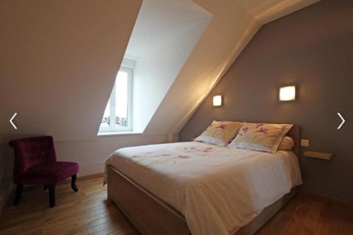 une chambre avec un lit et une chaise rouge dans l'établissement Cour historique La cour des trois rois 1, à Villedieu-les-Poêles