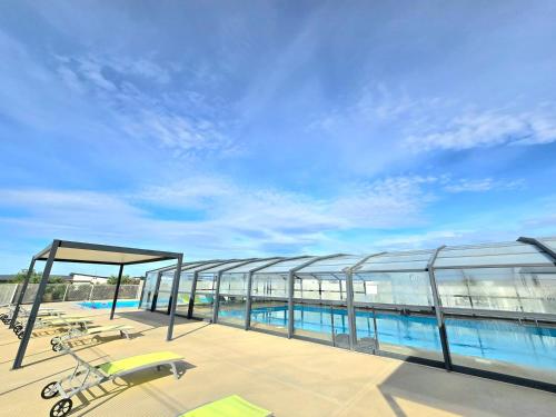 un immeuble avec une piscine et un ciel bleu dans l'établissement GRENATIERE, à Pomérols