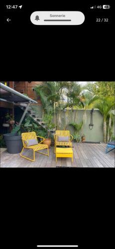 two yellow chairs sitting on top of a patio at Chambre De L étang in Saint-Paul
