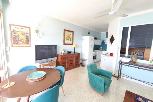 un salon avec une table et des chaises et une cuisine dans l'établissement Apartment with sea view balcony, à Ajaccio