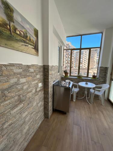 a living room with a stone wall and a table and chairs at Casa Annachiara in Palermo