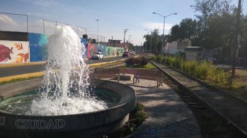 a fountain in the middle of a street with benches at Hostal Makea Pachuca in Pachuca de Soto