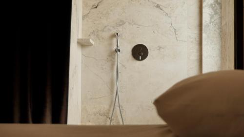 a shower in a stone wall with a metal shower head at Kiwi in Latina