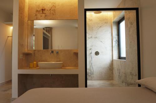 a bathroom with a sink and a shower with a mirror at Kiwi in Latina
