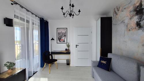 a living room with a couch and a table at City Break Apartment z gabinetem, 2 łazienkami, tarasem i garażem podziemnym w cenie in Rzeszów