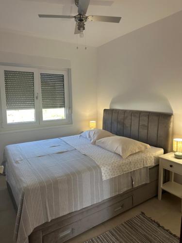 a bedroom with a large bed and two windows at Apartments Iva in Pakoštane