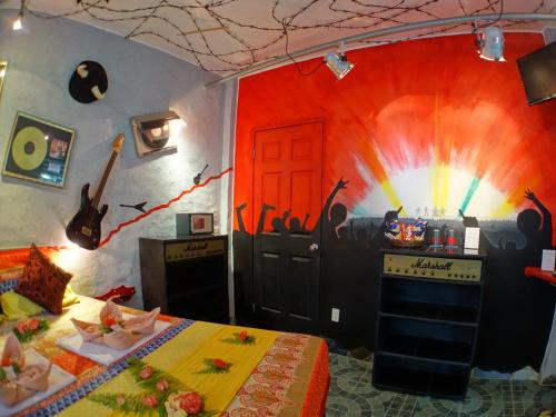 a room with a wall with a painting of a guitar at Takatuka Beach Resort in Sipalay
