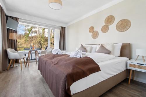 a bedroom with a large bed and a table with chairs at Beachside Grömitz - 21 Apartments, Pool & Sauna direkt am Meer in Grömitz