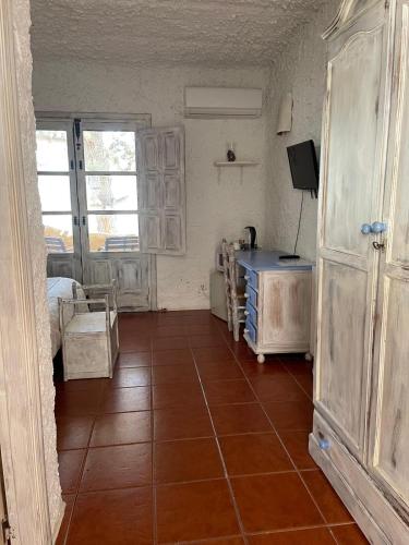 a room with a tiled floor and a room with a bed at Hotel Rural los Caracoles in Frigiliana