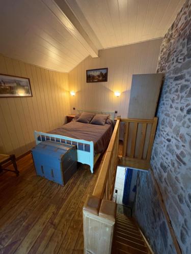 a bedroom with a bed and a stone wall at Petite maison avec cour fermée in Beaulieu-sur-Dordogne