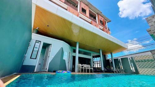 a building with a swimming pool in front of a building at Ratana Hotel Sakdidet, PHUKET TOWN in Phuket