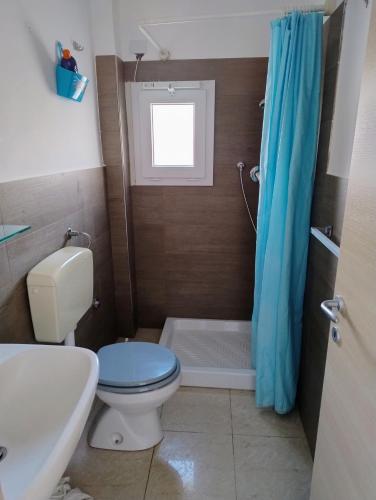 La salle de bains est pourvue de toilettes et d'un rideau de douche bleu. dans l'établissement Marleo, à Cava dʼAliga