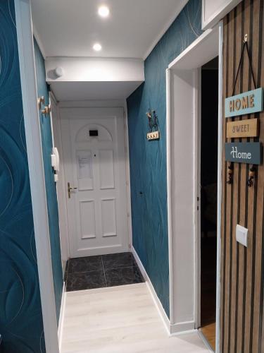 un couloir avec une porte blanche et des murs bleus dans l'établissement Home Sweet Home, à Calais