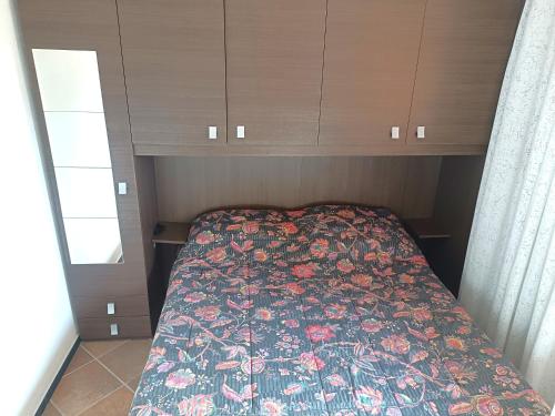 a bedroom with a bed with a floral comforter at Borgo Stalle in Prato Nevoso