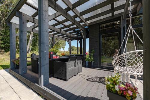 a pergola with a swing on a patio at Namelis Ramybėlė in Siauliškiai