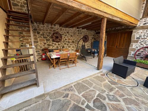 a patio with a table and chairs and a stone wall at Petite maison avec cour fermée in Beaulieu-sur-Dordogne