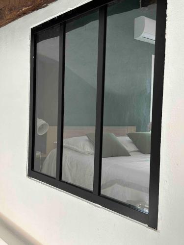 - une fenêtre dans une chambre avec un lit dans l'établissement Appartement Duplex Lumineux au Centre de Grasse, à Grasse