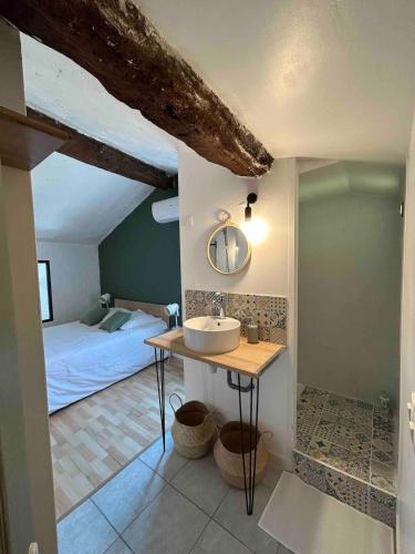 La salle de bains est pourvue d'un lavabo et d'un lit dans la chambre. dans l'établissement Appartement Duplex Lumineux au Centre de Grasse, à Grasse