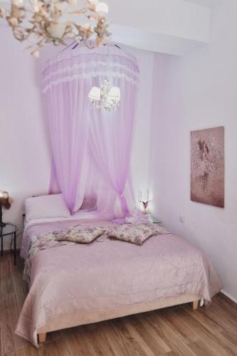a bedroom with a bed with a pink canopy at Studio Lefaki in Rethymno Town