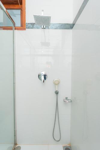 a shower in a bathroom with a glass wall at Hotel Coconut Bar Sea Lodge in Beruwala