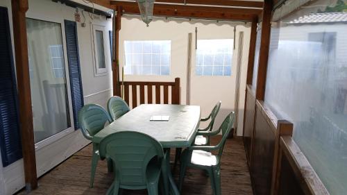 - une table et des chaises sur la terrasse couverte d'une maison dans l'établissement MOBIL-HOME 6 personnes St Vivien de Médoc 33, à Saint-Vivien-de-Médoc