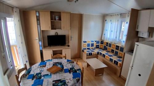 un petit appartement avec une chambre avec un lit et une télévision dans l'établissement MOBIL-HOME 6 personnes St Vivien de Médoc 33, à Saint-Vivien-de-Médoc