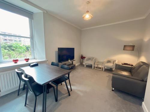 a living room with a table and a couch at Two bed apartment in Edinburgh