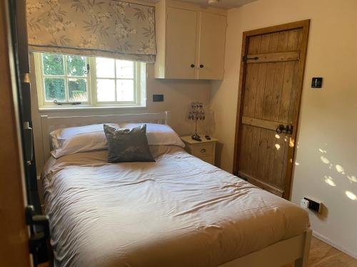 a bedroom with a bed with a window and a windowtaining at Belle in Ugley