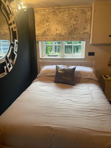 a bed in a bedroom with a window at Belle in Ugley