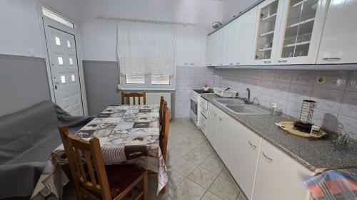 a kitchen with a sink and a table with chairs at Lucky Apartment in Nea Kalikratia