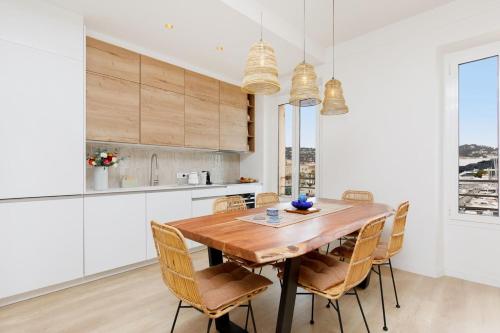 une cuisine avec une table et des chaises en bois dans l'établissement Modern 2 Bedroom Overlooking Cannes Old Port, à Cannes
