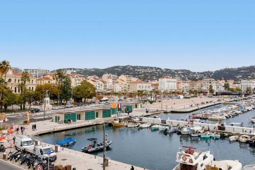 un port de plaisance avec des bateaux dans l'eau et une ville dans l'établissement Modern 2 Bedroom Overlooking Cannes Old Port, à Cannes