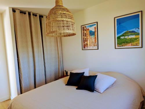 une chambre avec un lit avec deux oreillers dessus dans l'établissement Pré Madame, Terrasse, Parking, à Riom