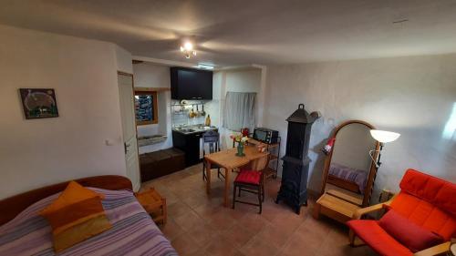 a room with a bed and a living room with a table at Le Petit Coeur de Cassaignes in Cassaignes