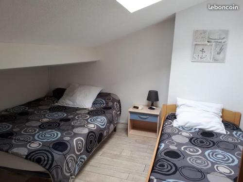 - une petite chambre avec 2 lits et une table de nuit dans l'établissement Jolie maison rénovée aux pieds des dunes, à Bretignolles-sur-Mer