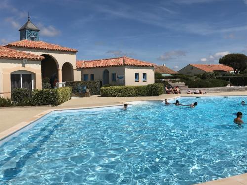 un groupe de personnes dans une piscine dans l'établissement Jolie maison rénovée aux pieds des dunes, à Bretignolles-sur-Mer