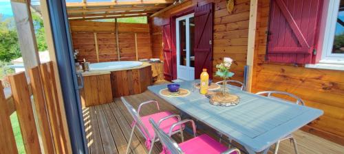 une table et des chaises sur le pont d'une cabine dans l'établissement Le nid des Garrigues avec Jacuzzi privé, à Saint-Geniès