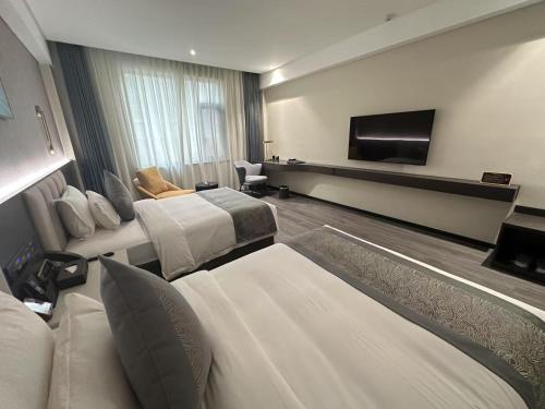 a hotel room with two beds and a flat screen tv at 巴域永源酒店 in Phumĭ Bavĕt (2)