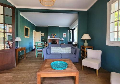 un salon avec un canapé bleu et une table dans l'établissement MAYIE THERESA - Belle villa bascolandaise entre lac et mer, à Soorts-Hossegor