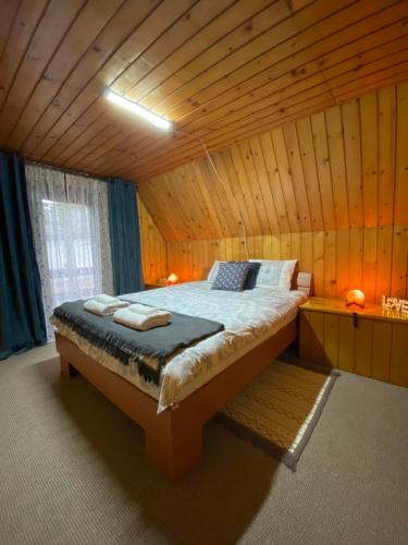 a bedroom with a bed in a wooden room at Viridian Three Accommodation, Three Winds in Divčibare