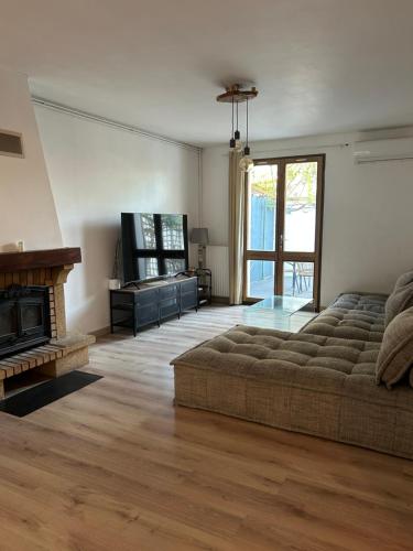 un soggiorno con divano e camino di Maison 3 chambres, piscine privée terrain de pétanque a Carcassonne