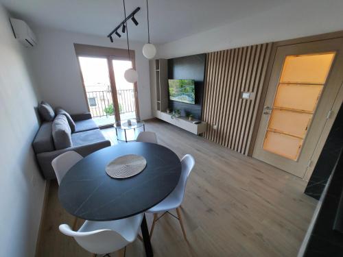 a living room with a black table and white chairs at Apartmani Central A20 & Free parking in Vrnjci