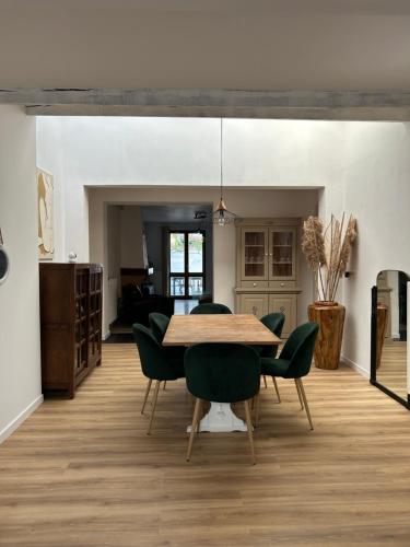 una sala da pranzo con un tavolo e sedie verdi di Maison 3 chambres, piscine privée terrain de pétanque a Carcassonne