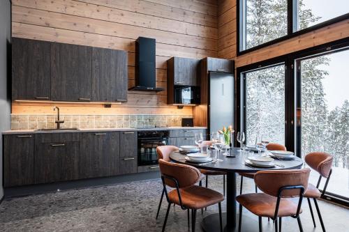 a dining room with a table and chairs in a kitchen at Villa Draivi B By Hilla Villas - 3BR and alcove in Kittilä