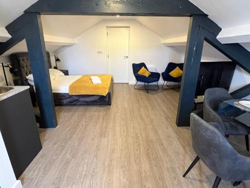 ein Schlafzimmer mit einem Bett und zwei blauen Stühlen in der Unterkunft Loft studio apartment, BL, Town Centre, Secure gated parking option, Modern, fresh and spacious living, Netflix ready TV, Wifi in Wellingborough