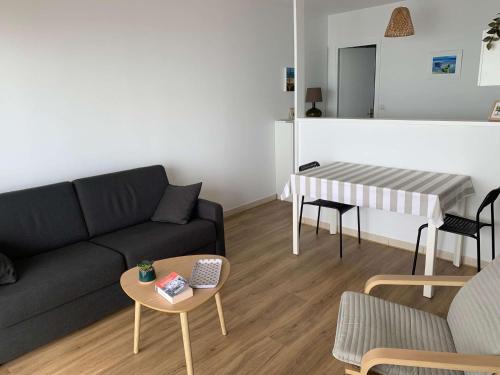 un salon avec un canapé et une table dans l'établissement Le Rocher de la Corniche Saint Hilaire de Riez, à Saint-Hilaire-de-Riez