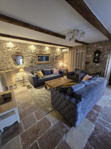 a living room with couches and a wooden table at Villa Mara Lustica Bay Retreat near Kotor, Tivat in Tivat