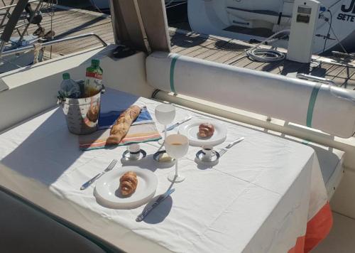 une table avec des assiettes de nourriture sur un bateau dans l'établissement Maison d'hôte de la mer-bateau à quai-SeaGuesthouse66, à Canet