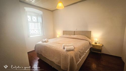 イドラにあるLuljeta's Guest Houseのベッドとタオル2枚のある寝室