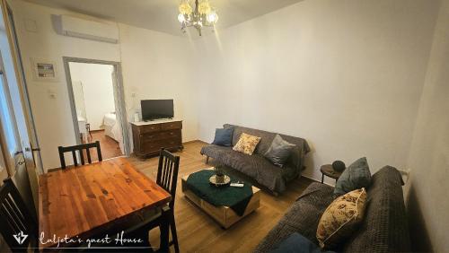 イドラにあるLuljeta's Guest Houseのソファとテーブルのあるリビングルーム